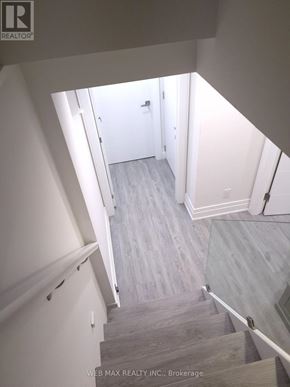 Toronto (Dorset Park) apartment for rent - A staircase with a glass railing and wooden steps.