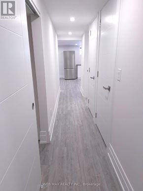 Toronto (Dorset Park) apartment for rent - A long hallway with white walls and wood flooring.