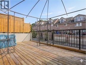 Cambridge townhouse for rent - A wooden deck with a metal railing and a blue tarp on it.