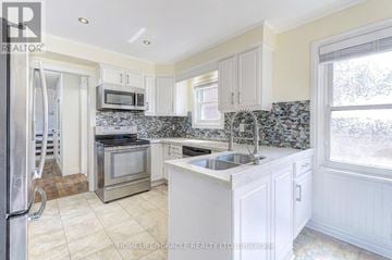 Brampton (Fletcher's West) apartment for rent - A kitchen with white cabinets and a tiled backsplash.