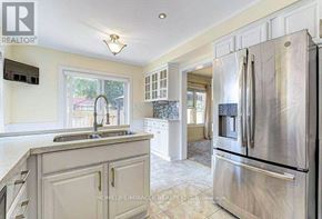 Brampton (Fletcher's West) apartment for rent - A kitchen with a refrigerator, sink, and cabinets.