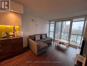 Toronto (Bayview Village) condo for rent - A living room with a grey couch and a television.