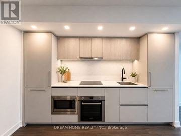 Toronto (North St. James Town) condo for rent - A modern kitchen with a stainless steel oven and microwave.