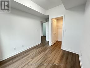 Toronto (Cliffcrest) condo for rent - A white room with wood flooring and a doorway leading to another room.
