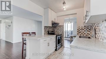 Toronto (L'amoreaux) condo for rent - A kitchen with a white counter top and a black and white tiled backsplash.