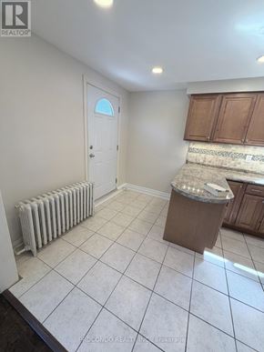 Mississauga (Port Credit) multi-family for rent - A room with a white tile floor and a white door.