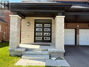 Brampton (Northwest Brampton) apartment for rent - A house with a black front door and two garage doors.
