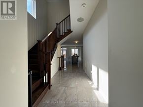 Brampton (Northwest Brampton) apartment for rent - A hallway with a staircase and a window letting in sunlight.