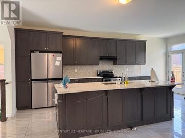 Brampton (Northwest Brampton) apartment for rent - A kitchen with dark brown cabinets and a stainless steel refrigerator.