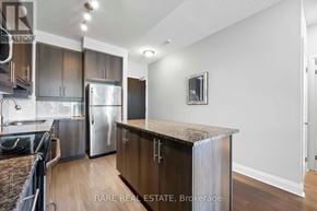 Toronto (Islington-City Centre West) condo for rent - A kitchen with a stainless steel refrigerator and a wooden island.