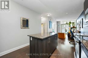 Toronto (Islington-City Centre West) condo for rent - A modern kitchen with a granite countertop and a framed mirror on the wall.