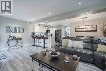 Stoney Creek townhouse for rent - A modern living room with a grey sofa and a wooden coffee table.