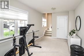 Hamilton (Ancaster) townhouse for rent - A room with a workout station and a staircase.