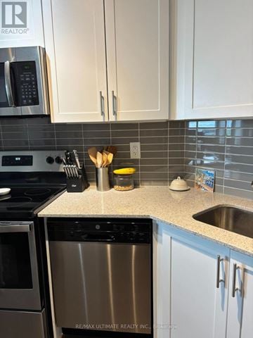 Grimsby (Grimsby Beach) condo for rent - A kitchen with a stainless steel dishwasher and white cabinets.