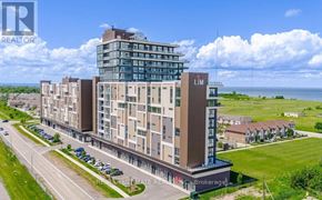 Grimsby (Grimsby Beach) condo for rent - A large building with the letters "LM" on it is surrounded by green grass and a clear sky.