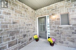 Thorold (Hurricane/Merrittville) apartment for rent - A grey door is flanked by two windows on a stone wall.