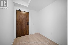 Hamilton (Riverdale) condo for rent - A room with a wooden door and a white wall.