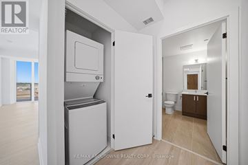 Hamilton (Riverdale) condo for rent - A white refrigerator is in a kitchen with a door open.