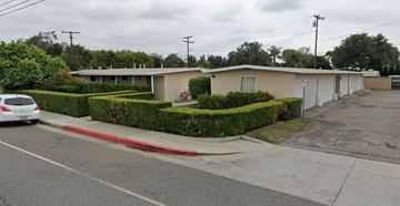 Fullerton apartment for rent - A white car is parked on the side of the road in front of a building.