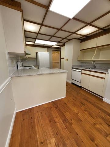 Burnaby apartment for rent - A kitchen with white cabinets and wooden floors.
