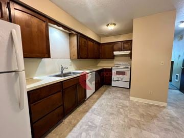 Longview apartment for rent - A kitchen with a white fridge and brown cabinets.