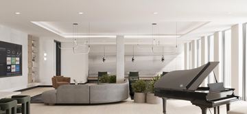 Bayonne apartment for rent - A grand piano sits in a spacious living room with a grey couch and a green plant.