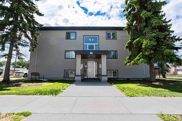 Edmonton apartment for rent - A modern two-story building with a grey facade and a large front door.