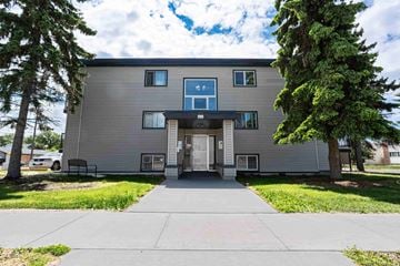 Edmonton apartment for rent - A modern two-story building with a grey facade and a large front door.