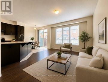 Milton (Cb Cobban) townhouse for rent - A well-lit living room with a beige sofa and a coffee table.
