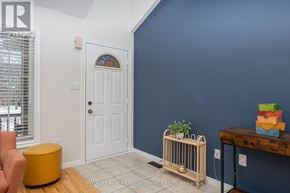 Halton Hills (Georgetown) apartment for rent - A room with a white door, a yellow ottoman, and a wooden table with a plant on it.