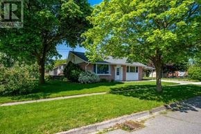 Halton Hills (Georgetown) apartment for rent - A house with a white door and windows is surrounded by green trees.