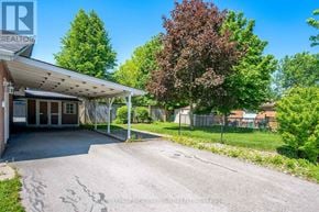 Halton Hills (Georgetown) apartment for rent - A realtor photo of a property with a driveway and trees.
