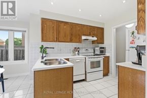 Caledon (Bolton East) apartment for rent - A kitchen with white appliances and wooden cabinets.