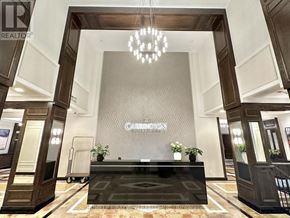 Toronto (Banbury-Don Mills) condo for rent - A reception area with a black reception desk and a chandelier hanging from the ceiling.