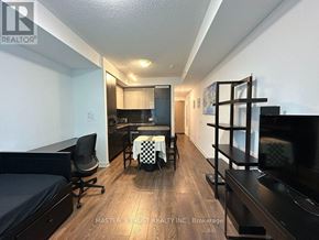 Toronto (Waterfront Communities) condo for rent - A bedroom with a bed, a chair, and a table.