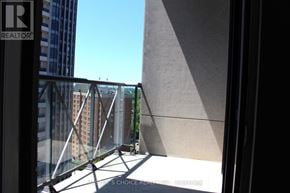 Toronto (Willowdale East) condo for rent - A balcony with a glass railing and a building in the background.