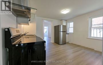 Barrie (Codrington) duplex for rent - A kitchen area with a black fridge and stove top oven.