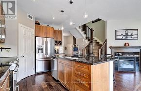 Ottawa townhouse for rent - A well-lit kitchen with wooden cabinets and a stainless steel refrigerator.