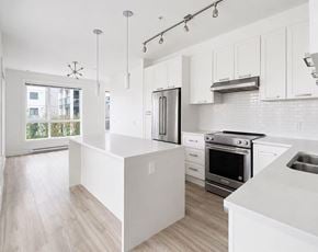 Langley apartment for rent - A modern kitchen with white cabinets and a large island.