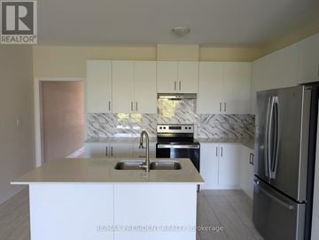 Grey Highlands townhouse for rent - A kitchen with white cabinets and a marble backsplash.