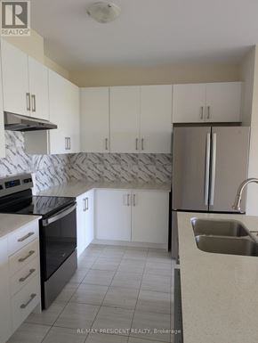Grey Highlands townhouse for rent - A kitchen with white cabinets and a marble backsplash.