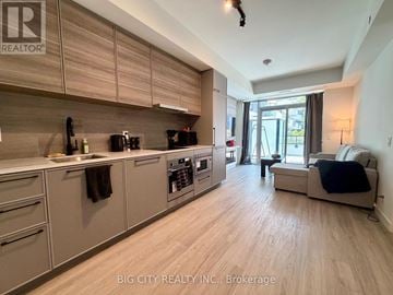 Toronto (The Beaches) condo for rent - A well-lit kitchen with wooden cabinets and a large island.