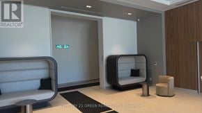 Burlington (Brant) condo for rent - A modern waiting room with a sofa, armchair, and a pod-like chair.