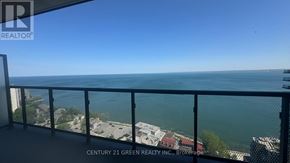 Burlington (Brant) condo for rent - A balcony overlooks a city and the ocean.