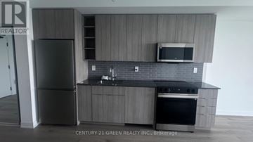 Burlington (Brant) condo for rent - A kitchen with a refrigerator, microwave, oven and a counter top.