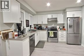 Kitchener townhouse for rent - A modern kitchen with white cabinets and stainless steel appliances.