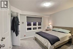 Kitchener townhouse for rent - A bedroom with a bed, nightstand, and window.