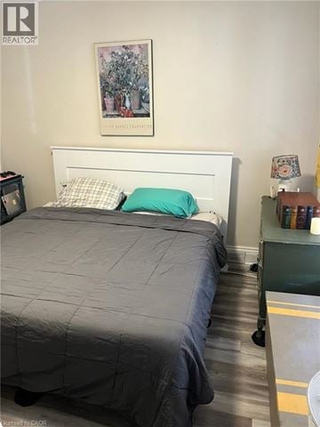 Hamilton apartment for rent - A bedroom with a bed, nightstand, and a painting on the wall.