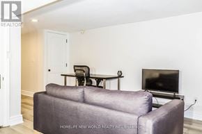 Toronto (Trinity-Bellwoods) apartment for rent - A living room with a grey couch and a television.