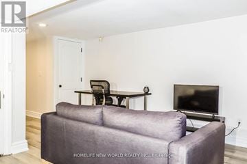 Toronto (Trinity-Bellwoods) apartment for rent - A living room with a grey couch and a television.